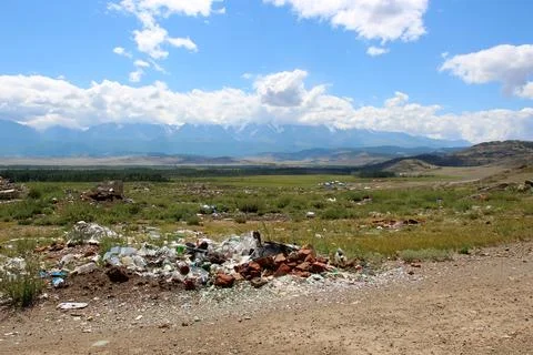 The problem of environmental pollution. Garbage dump in a field near beautifu Stock Photos