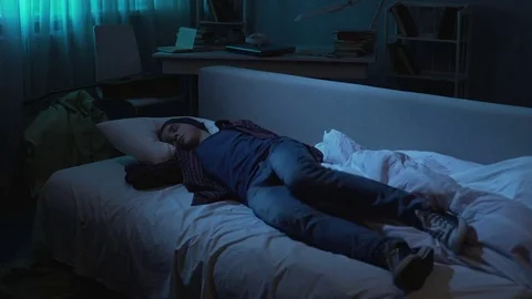 Problem lazy young man going bed and sleeping after student party, tiredness Stock Footage 85162950