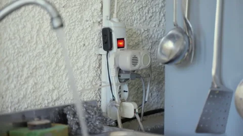 Problem of an open water flowing tap and switched outlet socket, high voltage Stock Footage 302175002