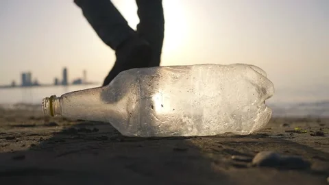 Problem of plastic garbage discarded Pet Bottles figure of a man on the beach Stock Footage 238899132