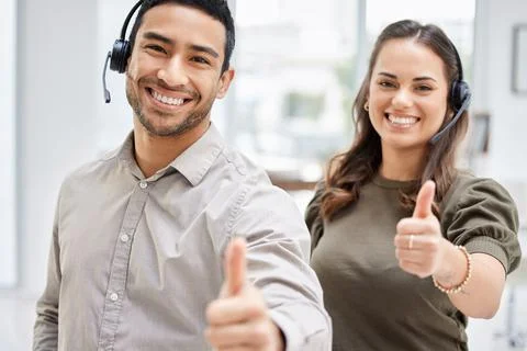 Problem solved. Cropped portrait of two young call center agents giving thumbs Foto stock