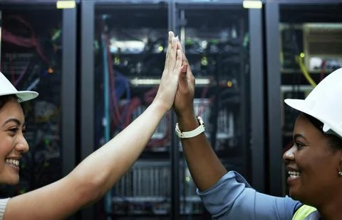 Problem solved. two attractive female programmers high fiving in a server room. Foto stock