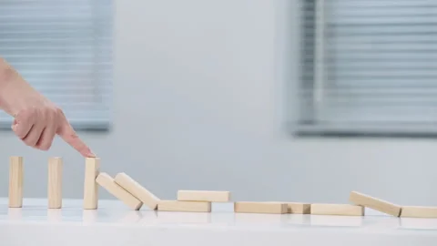 Problem solving closeup of business hand stopping the fall of wooden block like Stock Footage 328990695
