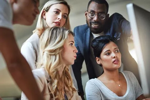 Problem solving done as a unit. Shot of a group of colleagues using a computer Stock Photos