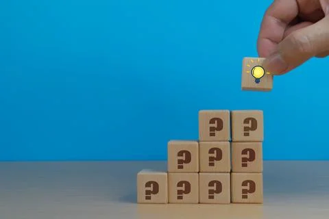 Problem solving, hand holding icon on pile of question mark icons Fotos de archivo