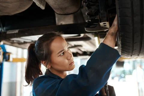 Problem solving is a huge part of the job. a female mechanic working under a Foto stock