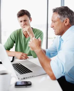 Problem solving together. A mature executive looking over some work on a laptop Stock Photos