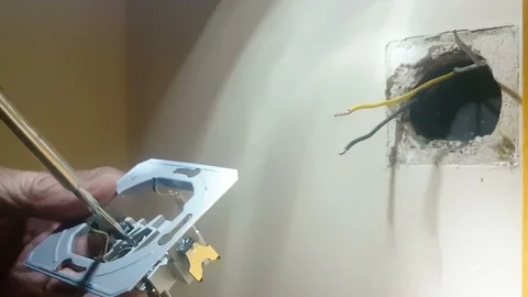 Problematic electrical outlet is changed by a man at a house. Stock Footage 91746637