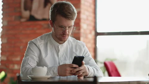 Problematic internet use by modern smartphone, adult man is sitting in cafe Stock Footage 172581073