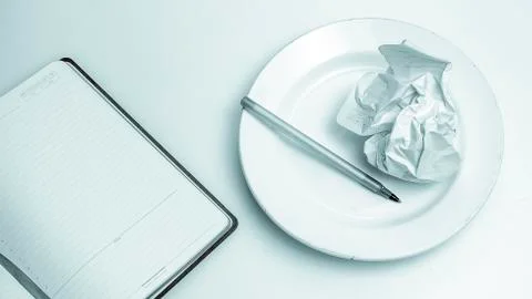 Problems of creativity. Pen and crumpled paper wads on a plate. Stock Photos