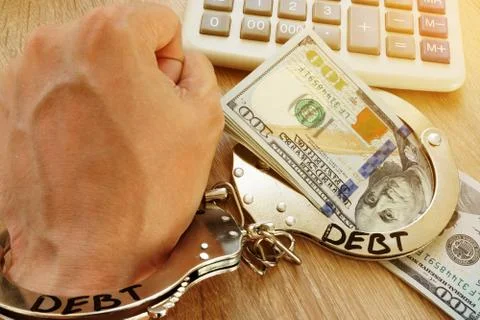 Problems with debt. Hand in handcuffs and money. Foto stock