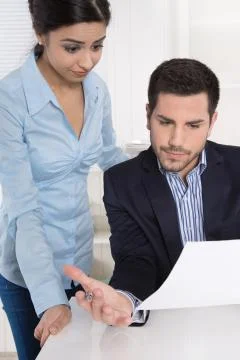 Problems at work: boss criticizes his female colleague and blame her. Stock Photos