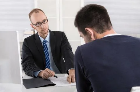 Problems at workplace: boss critic his employee because of his behavior. Stock Photos
