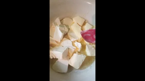 Proccess of making shortbread dough for a pie, melting butter. Vertical 4k Stock Footage 290788344