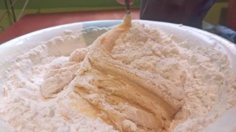 Proccess of making shortbread dough for a pie, mixing with spoon. Horizontal 4k Stock Footage 292885140