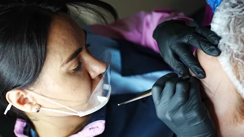 Procedure of eyebrow microblading. A master in black gloves is doing a blending Stock Footage 199962543