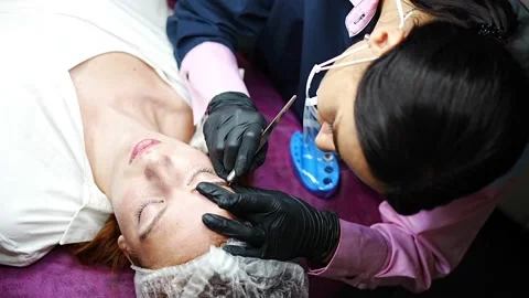 Procedure of eyebrow microblading. A master in black gloves is doing a blending Stock Footage 199962983