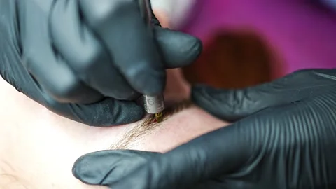 Procedure of eyebrow microblading. A master in black gloves is doing a blending Stock Footage 200831919