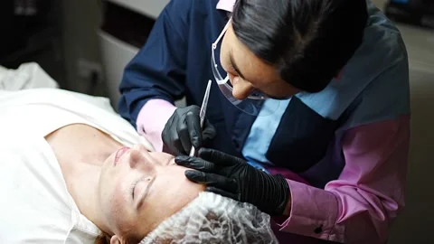 Procedure of eyebrow microblading. A master in black gloves is doing a blending Stock Footage 200831964