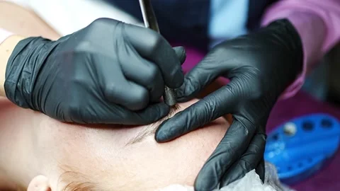 Procedure of eyebrow microblading. A master in black gloves is doing a blending Stock Footage 200832021