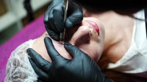 Procedure of eyebrow microblading. A master in black gloves is doing a blending Stock Footage 200832122