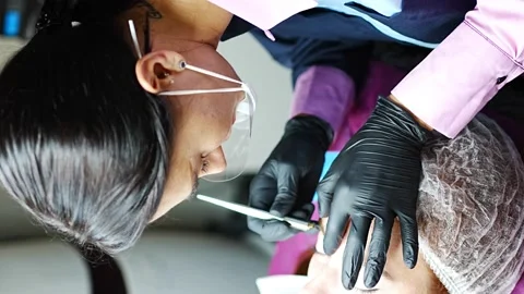 Procedure of eyebrow microblading. A master in black gloves is doing a blending Stock Footage 200832162