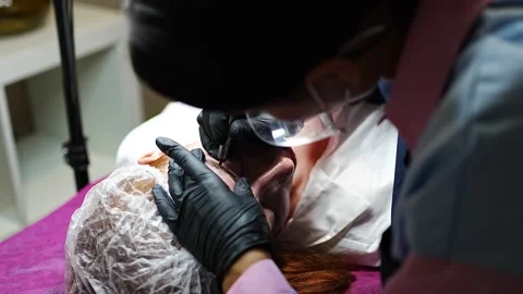 Procedure of eyebrow microblading. A master in black gloves is doing a blending Stock Footage 200832186