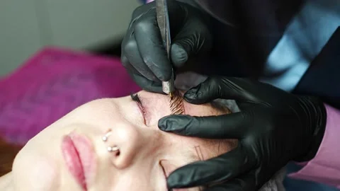 Procedure of eyebrow microblading. A master in black gloves is doing a blending Stock Footage 200832249