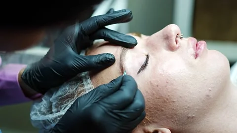 Procedure of eyebrow microblading. A master in black gloves is doing a blending Stock Footage 200832521