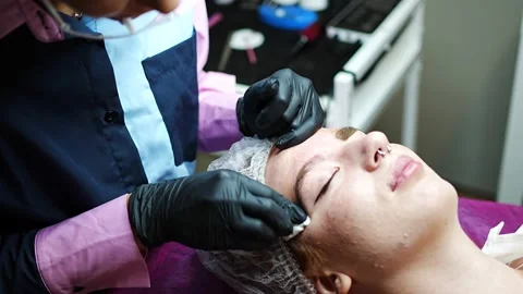 Procedure of eyebrow microblading. A master in black gloves is doing a blending Stock Footage 200832599