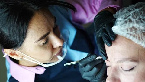 Procedure of eyebrow microblading. A master in black gloves is doing a blending Stock Footage 201079950