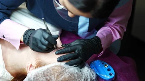 Procedure of eyebrow microblading. A master in black gloves is doing a blending Stock Footage 201080409