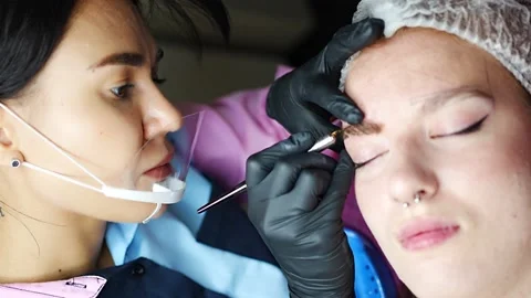 Procedure of eyebrow microblading. A master in black gloves is doing a blending Stock Footage 201367371