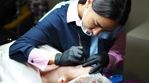 Procedure of eyebrow microblading. A master in black gloves is doing a blending Stock Footage 201474119