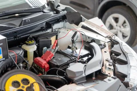 Process accumulator charging. Image of a car battery and jumper cables Stock Photos
