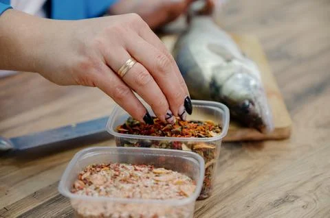 The process of adding a spice and salt mixture to seafood Stock Photos