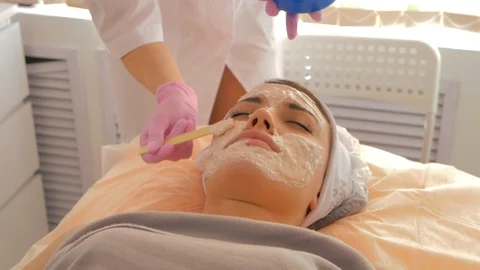 The process of applying alginate mask on the woman's face Stock Footage 118920796
