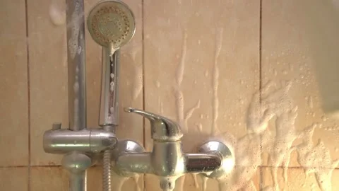 The process of applying cleaning agent to the walls in the shower. White foam is Stock Footage 166430983