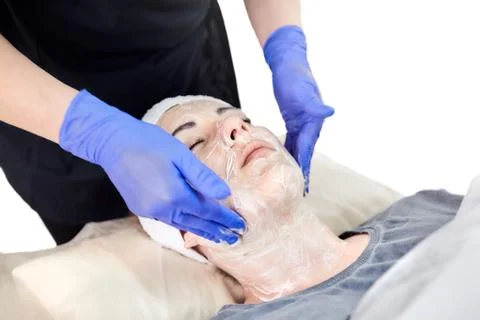 The process of applying a cosmetic cream on the face of a young woman Stock Photos