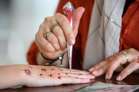 The process of applying mehendi: the artist makes a temporary henna tattoo Stock Photos