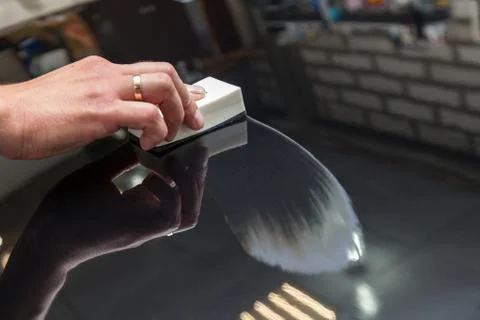 The process of applying a nano-ceramic coating on the car's hood by a male wo Stock Photos