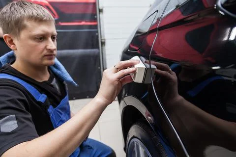 The process of applying a nano-ceramic coating on the car's fender by a male  Stock Photos