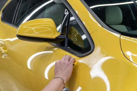 Process of applying a nano-ceramic coating on the yellow car. Stock Photos