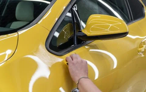 Process of applying a nano-ceramic coating on the yellow car. Stock Photos