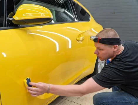 Process of applying a nano-ceramic coating on the yellow car. Stock Photos