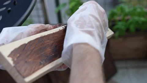 Process of applying oil-based brown colour paint on wooden plank surface with Video stock 226147378