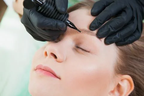 Process of applying permanent makeup tattoo pen machine Stock Photos