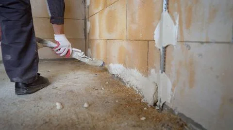 The process of applying plaster from a hose to the wall. Plasterer spraying p Stock Photos