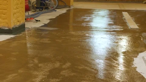The process of applying a primer with a roller and a spatula on a concrete floor Stock Footage 199836381