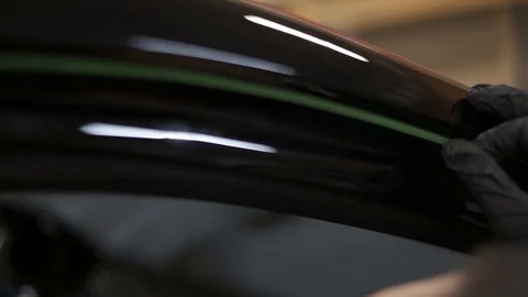 Process applying a protective black film to a car. Protective black film closeup Stock Footage 121410142